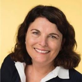 Smiling white woman with green eyes and shoulder-length brown hair.
